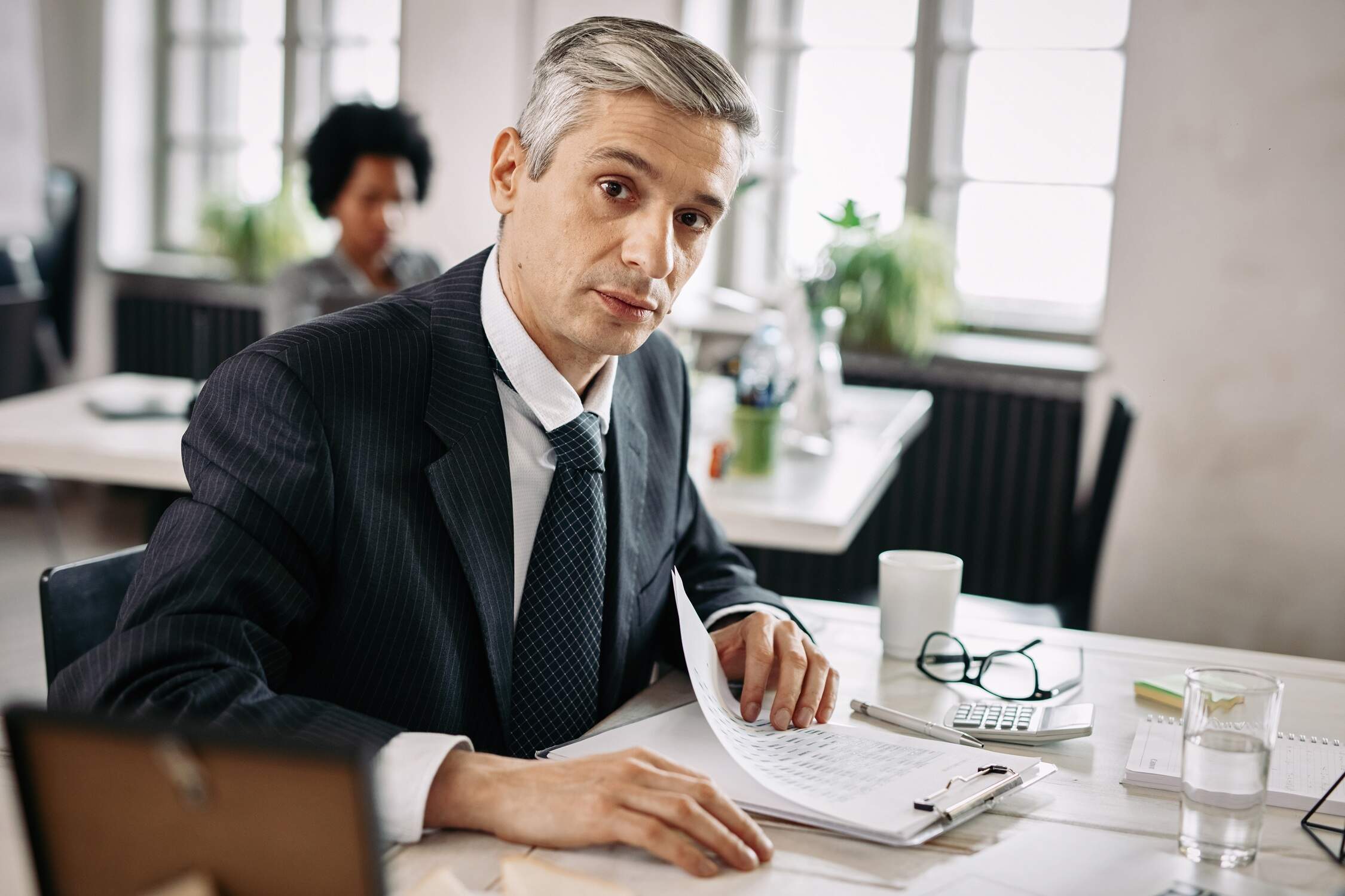 Portrait Of Businessman Doing Paperwork In The Office. - Contabilidade para Empresas em São Paulo | Fênix Contábil